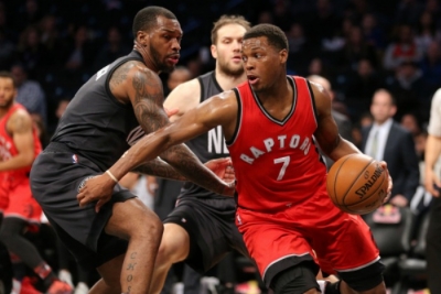 Sean Kilpatrick, Brooklyn Nets shooting guard, defending against Toronto Raptors guard Kyle Lowry, Nets Bojan Bogdanovic in the background