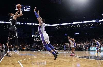 With 7.1 seconds left on the clock in overtime, Detroit Pistons center Andre Drummond (r) trying to prevent Brooklyn Nets guard Spencer Dinwiddie (l) from scoring a 3-pointer to no avail. The Nets defeat the Pistons 120-119