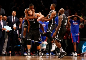 Brooklyn Nets center Brook Lopez is mobbed by teammates after he hits the buzzer-beating basket to lift the Nets to a 98-96 victory over the Detroit Pistons